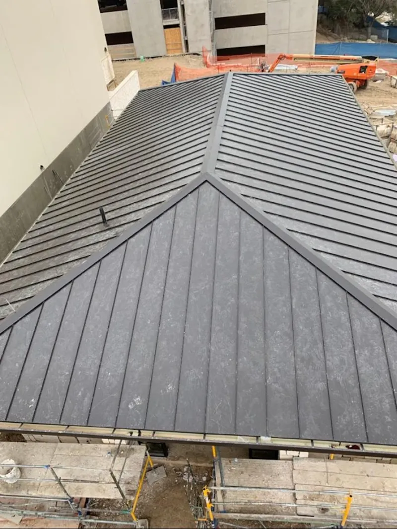 Commercial metal roof construction with crane equipment in Stevensville